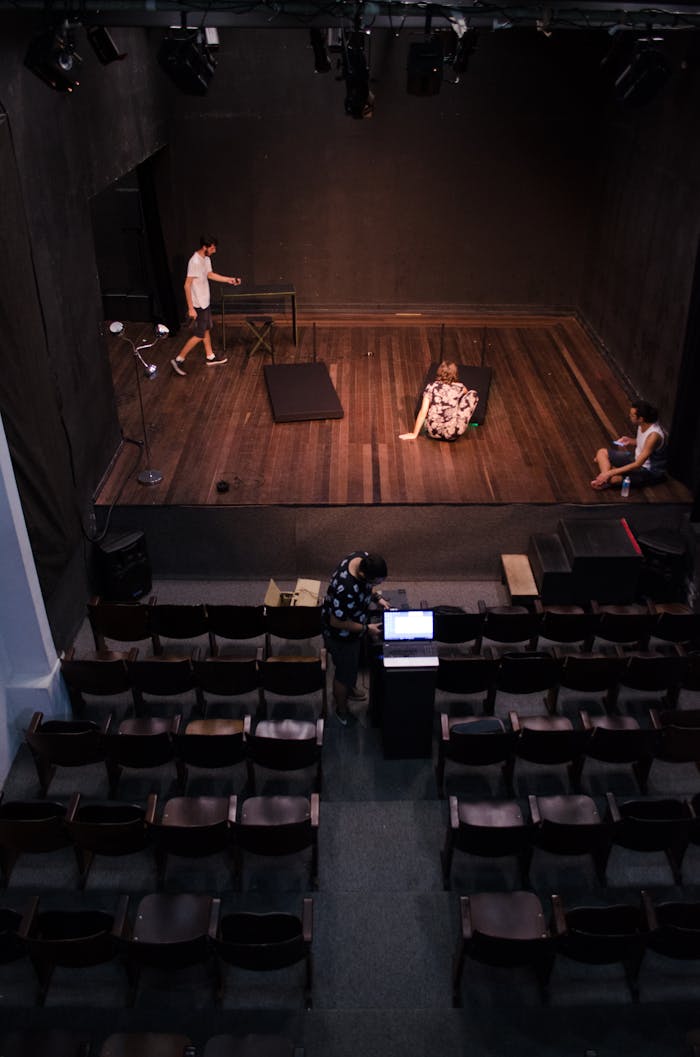 services-06 Actors rehearsing on stage in an empty theater, viewed from above.