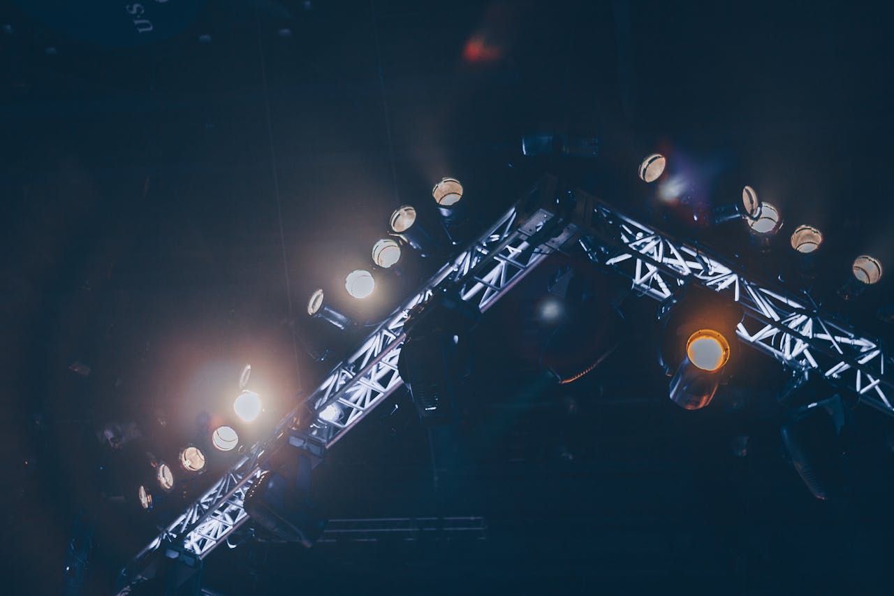 about-us Bright stage lights illuminate a concert venue, creating a vivid and celebratory atmosphere.